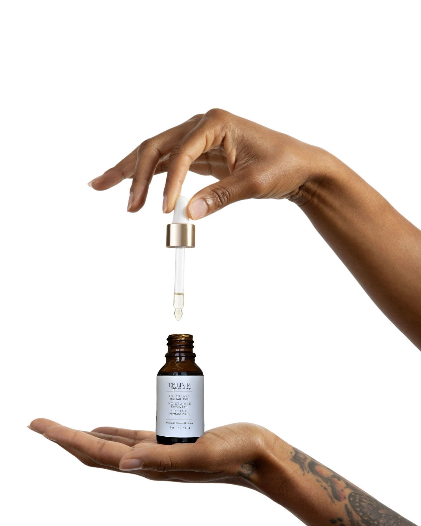 Hand holding a dropper over a small bottle with a white label on a white background